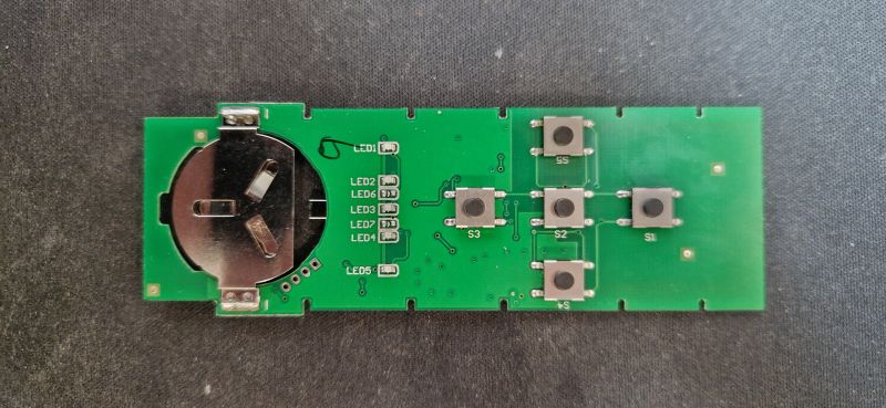 Circuit Board with RF Remote Buttons Image of an electronic circuit board with buttons and a battery holder.