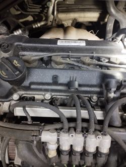 Silnik samochodu z widocznymi przewodami i elementami mechanicznymi.