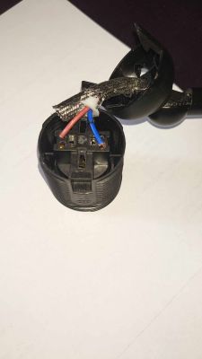 Zbliżenie na gniazdo oprawki E27 z dwoma włożonymi przewodami elektrycznymi, nie do końca zamontowanej lampki.