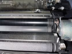 Konica 282: Błąd C2557, drukowanie czarnych stron mimo wymiany części, utwardzony toner