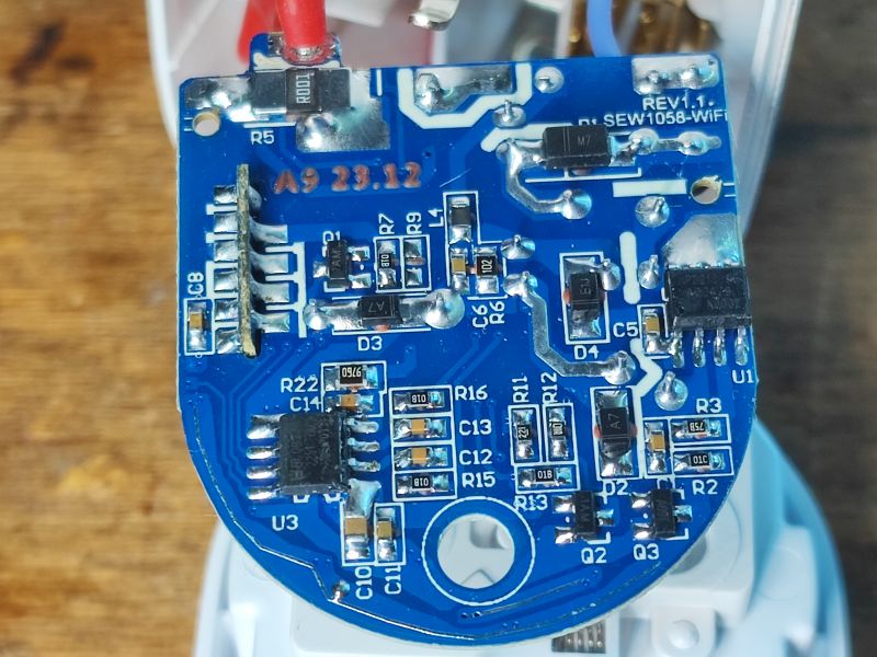 Widok wnętrza inteligentnej wtyczki z podświetleniem LED pokazujący płytkę PCB z komponentami elektronicznymi.
