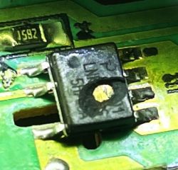 Zbliżenie na uszkodzony element elektroniczny na płytce drukowanej.