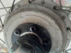 Zbliżenie na silnik rowerowy z widocznym numerem seryjnym M129321171436.