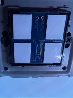 Close-up of a circuit board with four large white rectangles and two round holes at the top.