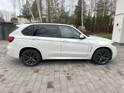 White SUV parked on a driveway, side view.