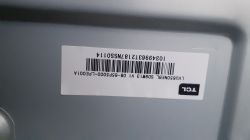 Etykieta z kodem kreskowym i logo TCL na szarym tle