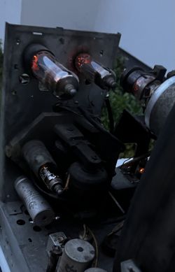 Zbliżenie na wnętrze telewizora lampowego Szmaragd 901 z widocznymi żarzącymi się lampami elektronowymi