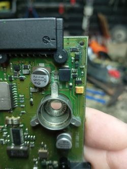 Close-up of a damaged green PCB with corrosion near connector and pins