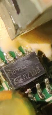 Zbliżenie na chip elektroniczny z widocznym oznaczeniem na płytce PCB.