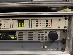 Panel przedni urządzenia rack: mierniki LED L/R, przełączniki i pokrętło, napis „VM-1110”