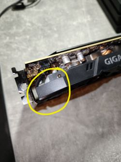 Zbliżenie na kartę graficzną GIGABYTE RTX 2060 z żółtym okręgiem zaznaczającym fragment obudowy przy wentylatorze.