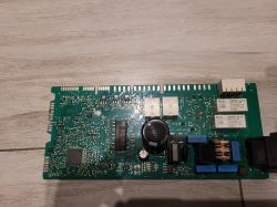 Płytka drukowana z komponentami elektronicznymi na tle drewnianej podłogi.