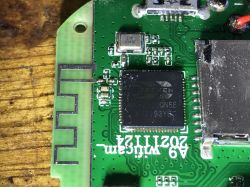 Close-up of a green printed circuit board with visible electronic components and a PCB antenna.