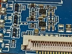Złącze taśmy FFC na niebieskiej płytce PCB z widocznymi pinami i czerwonym oznaczeniem