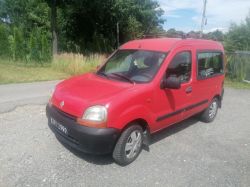 Red Renault Kangoo car parked on a gravel area.