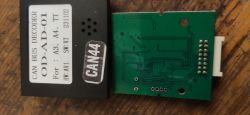 Otwarty dekoder CAN BUS z płytką PCB i białym złączem po prawej, na obudowie etykieta „CAN BUS DECODER”