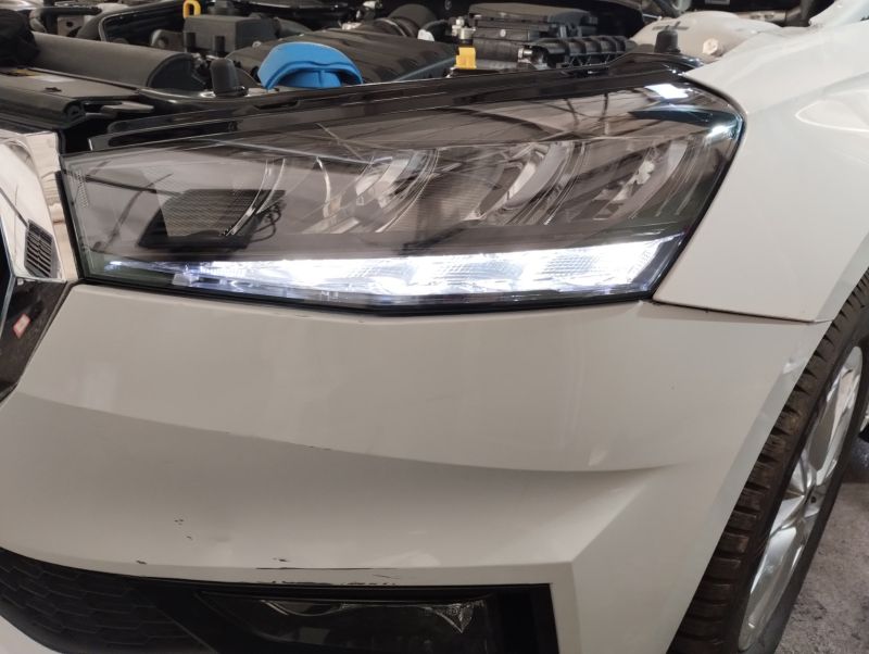 Przednia lampa LED włączona w samochodzie Skoda Fabia IV, widoczna z bliska z zaświeconymi światłami dziennymi.