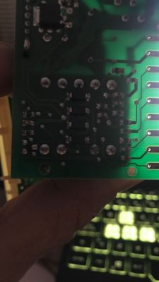 Zdjęcie ukazuje fragment płytki drukowanej z kilkoma lutowaniami i elementami elektronicznymi.