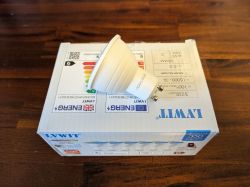 Aoycocr Bulb on LVWIT Box White Aoycocr LED bulb on LVWIT box, resting on a wooden table.