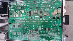 Wnętrze demontowanej ładowarki samochodu elektrycznego z widocznymi komponentami.