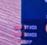 Close-up of a damaged PCB with visible TXD1, RXD1, and P7 pads.