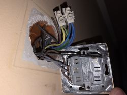 Zbliżenie na instalację elektryczną z przewodami i gniazdem w ścianie