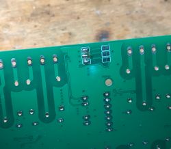 Bottom of a green PCB with several SMD components.
