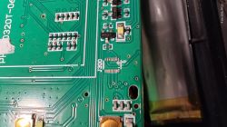 Part of a green PCB with exposed solder pads at connector J300