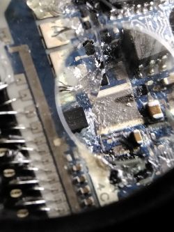 Close-up of a circuit board with visible damage and burn marks.