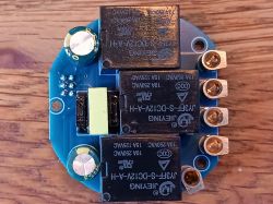Electronic Board with Relays Photo of an electronic board with two large relays and other components on a wooden background.