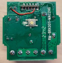 Printed circuit board with electronic components, including a jumper and a button.