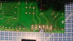 Uszkodzona płytka PCB z nadpalonym obszarem i widoczną korozją przy złączach