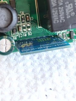 Close-up of a PCB with SMD components and a blue module at the edge