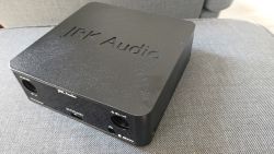Czarny amplituner JRK Audio Evothon z matową obudową, widziany z góry na szarym materiale.