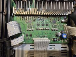 Wnętrze urządzenia: zielona płytka PCB z radiatorem, kondensatorami i taśmami przewodów