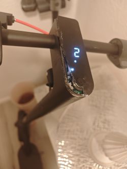 Pęknięty wyświetlacz hulajnogi elektrycznej Xiaomi Mi 4 Pro z widoczną elektroniką i podświetloną cyfrą „2”.