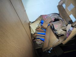 Damaged cardboard boxes with flooded supercapacitors in a room.