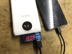 Powerbank Romoss Sense ładuje smartfon, tester USB pokazuje prąd 1.80A.