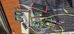 Electronics test setup with PCBs, breadboard, and many wires on a desk