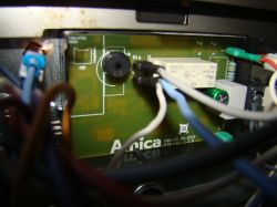 Wnętrze panelu sterowania kuchenką z widocznymi przewodami i płytką elektroniki.