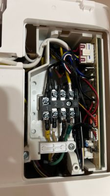 Interior of an electrical box with wires connected to terminals and a circuit board.