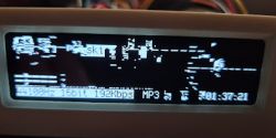 Distorted electronic display with graphic errors and music playback information.