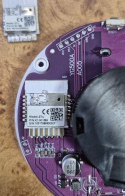 Close-up of a purple printed circuit board with a mounted ZTU electronic module and visible technical markings.