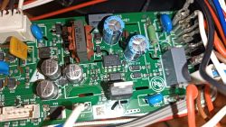 Zbliżenie na płytkę drukowaną z elementami elektronicznymi, takimi jak kondensatory, przekaźniki i przewody.