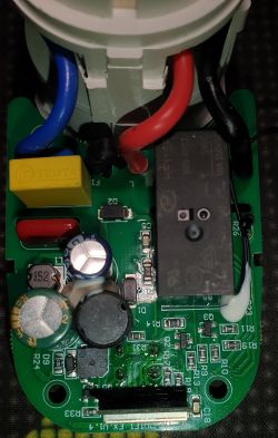 Electronic Board with Relay and EEPROM Close-up of an electronic board with various components, including a relay, capacitors, and wires.