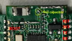 Circuit Board with Markings and Capacitor Close-up of a circuit board with marked points BOOT, RST, 3V3, TX, RX and a highlighted capacitor.