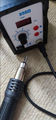 Soldering station with a hot air gun on a carpet.