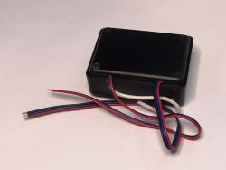 Black plastic electronic module with red, blue, and white wires extending from one side.