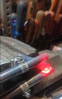 Rozgrzana rurka miedziana 15 mm w imadle, podgrzewana uzwojeniem z transformatora