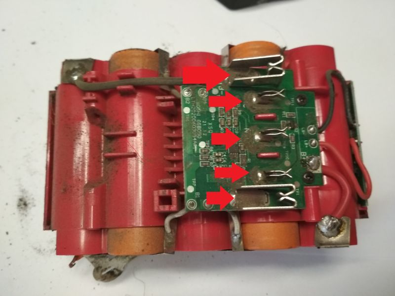 Wnętrze akumulatora Megatto 18V, widoczne ogniwa i płytka PCB z zaznaczonymi punktami lutowania.